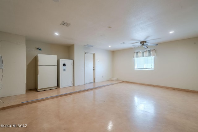 basement with ceiling fan and white refrigerator