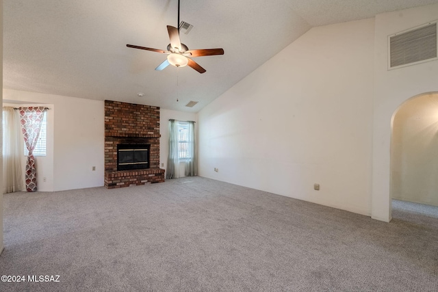 unfurnished living room with ceiling fan, plenty of natural light, carpet flooring, and vaulted ceiling