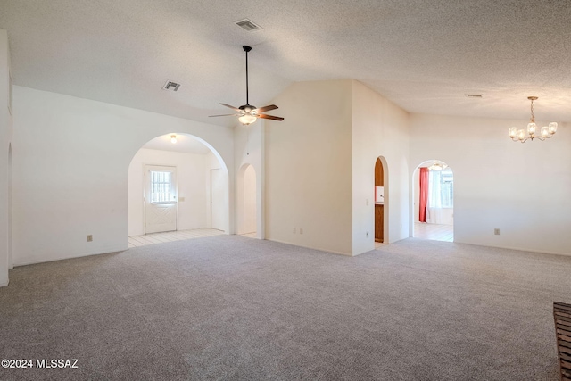 empty room with ceiling fan with notable chandelier, light carpet, and high vaulted ceiling