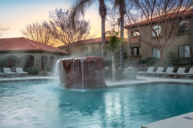 pool at dusk with pool water feature