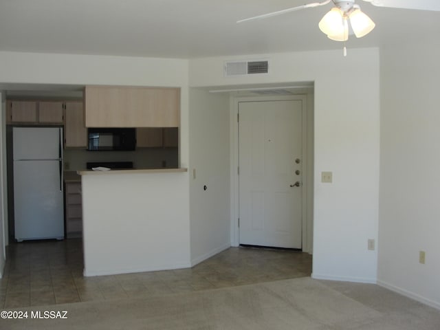 kitchen featuring light colored carpet, ceiling fan, and white fridge