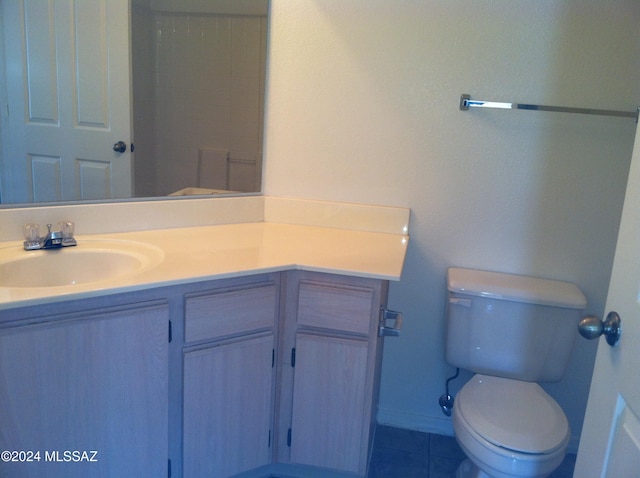 bathroom with toilet, vanity, and tile patterned floors