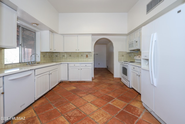 kitchen with white cabinetry, white appliances, sink, and tasteful backsplash