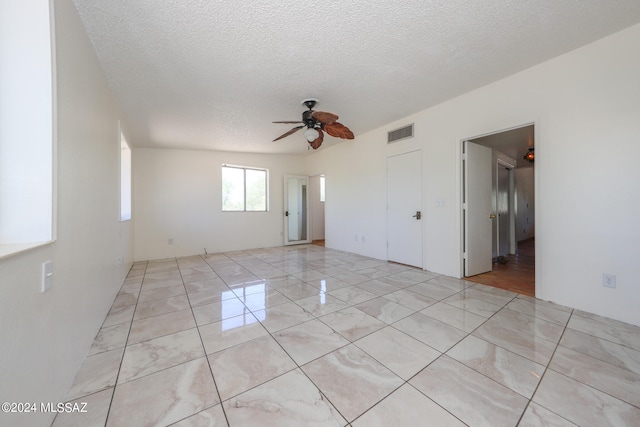 empty room featuring ceiling fan and a textured ceiling