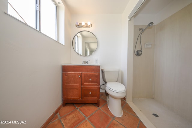 bathroom featuring tiled shower, vanity, and toilet