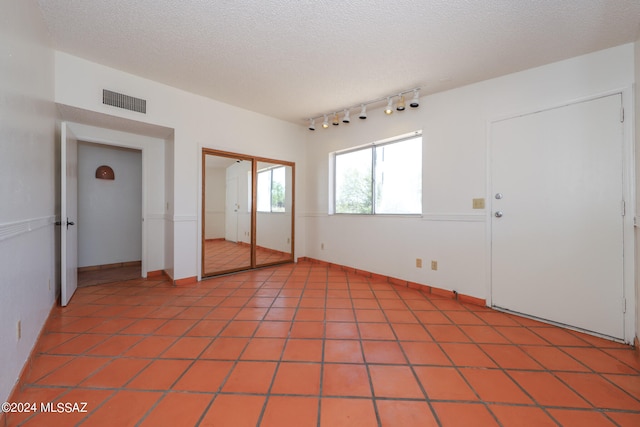 unfurnished bedroom featuring light tile patterned floors and a textured ceiling