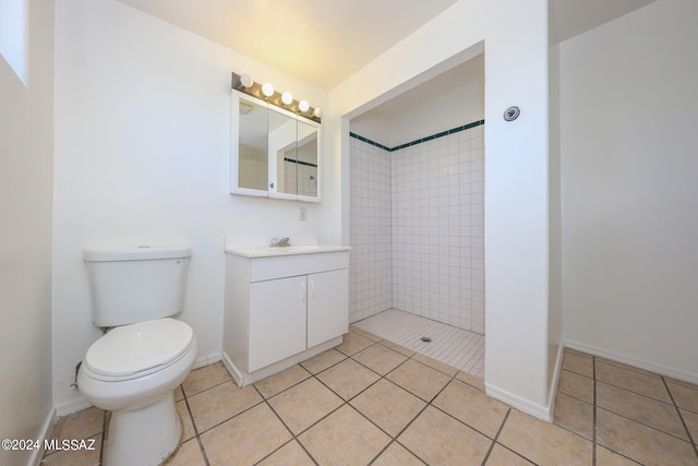 bathroom featuring tile patterned flooring, vanity, toilet, and a tile shower