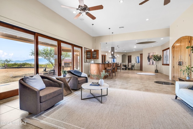 living area featuring light tile patterned flooring, recessed lighting, a high ceiling, visible vents, and a ceiling fan