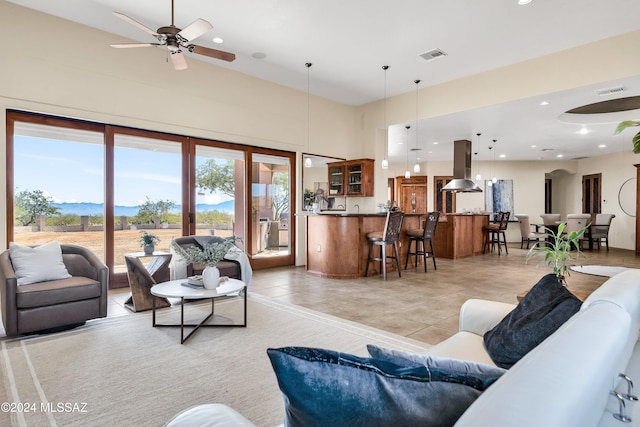 living area with light tile patterned floors, ceiling fan, visible vents, and recessed lighting