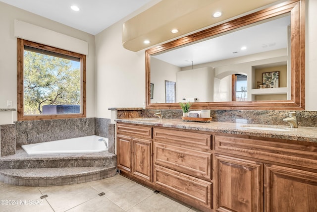 bathroom with double vanity, a sink, a bath, and tile patterned floors