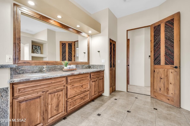 bathroom with double vanity, recessed lighting, a sink, and tile patterned floors