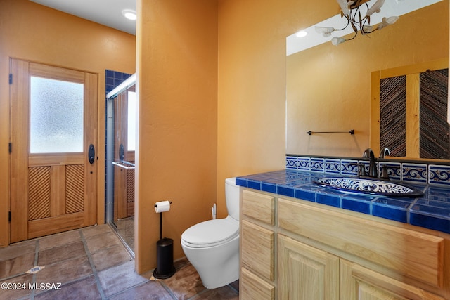 bathroom with a stall shower, vanity, and toilet