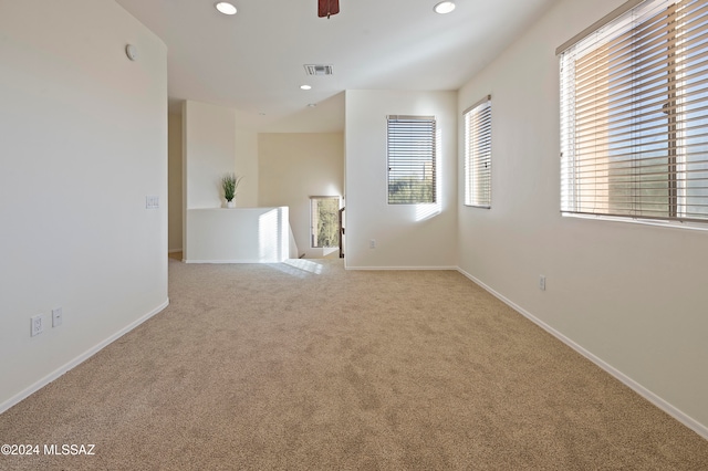 carpeted spare room with ceiling fan