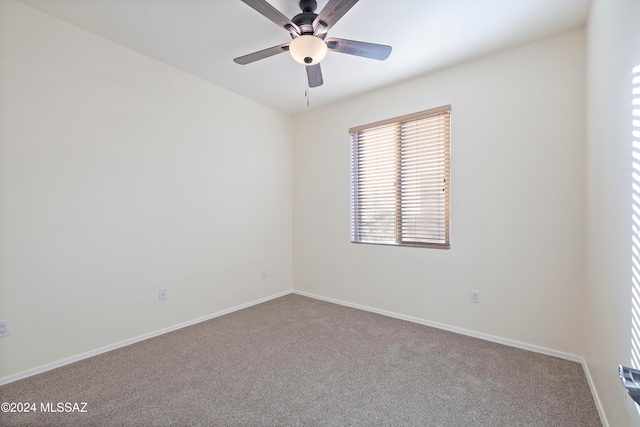 carpeted spare room featuring ceiling fan