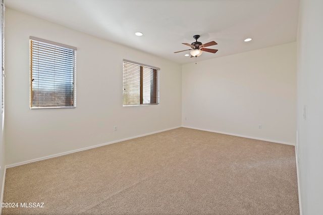 spare room featuring ceiling fan and light carpet