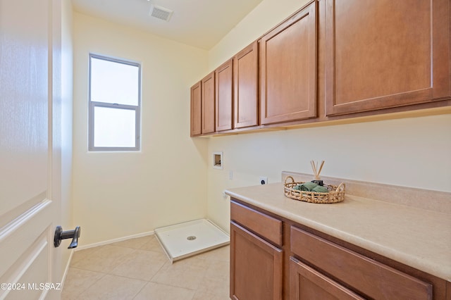 laundry area with hookup for a washing machine, cabinets, light tile patterned floors, and hookup for an electric dryer