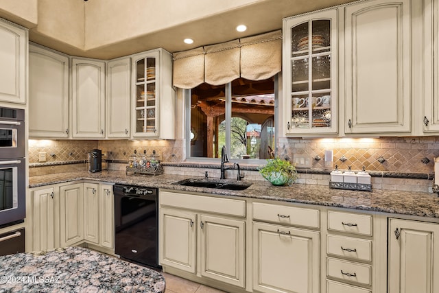 kitchen featuring dark stone counters, dishwasher, decorative backsplash, sink, and light tile patterned flooring