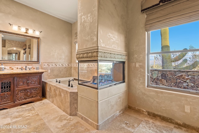 bathroom with vanity and tiled tub