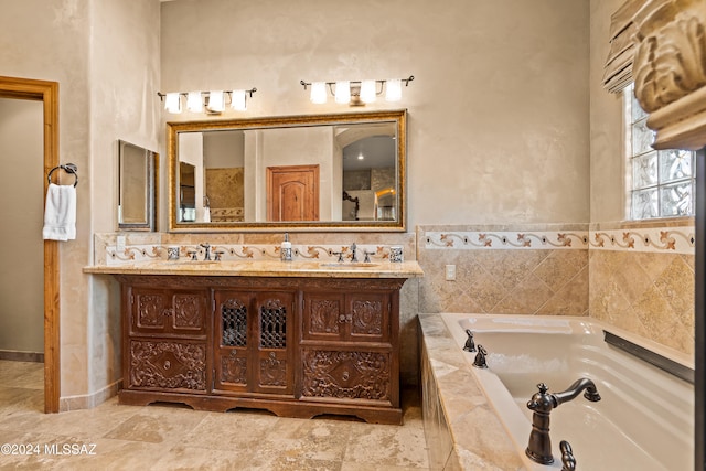 bathroom featuring vanity and tiled tub