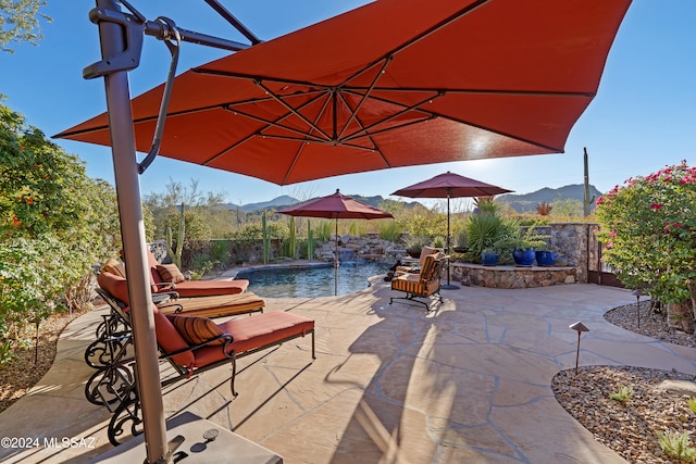 view of patio with a mountain view and pool water feature