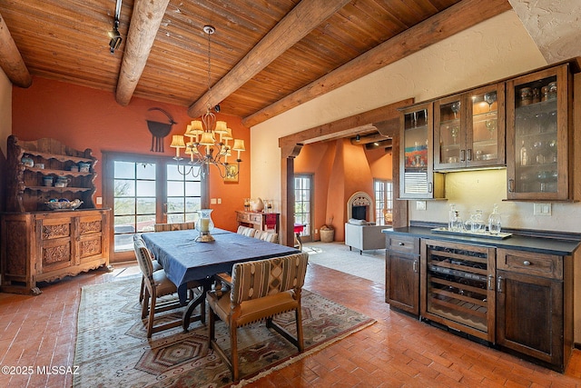 dining area with indoor bar, rail lighting, a healthy amount of sunlight, and wood ceiling