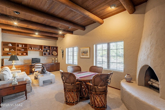 dining space featuring beamed ceiling, light colored carpet, and wood ceiling