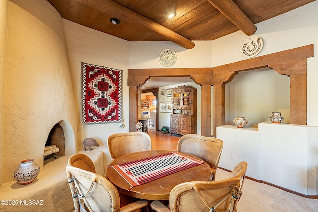 dining area featuring beamed ceiling, wood ceiling, and decorative columns