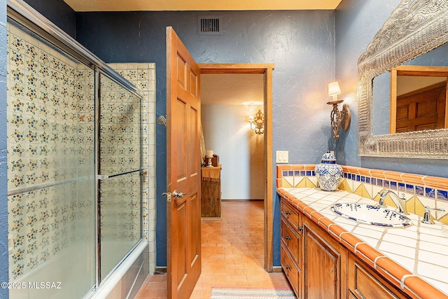 bathroom featuring vanity and enclosed tub / shower combo