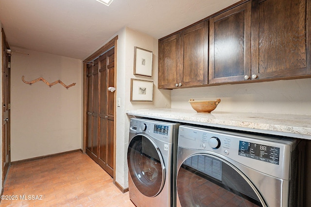 laundry room featuring washer and dryer and cabinets