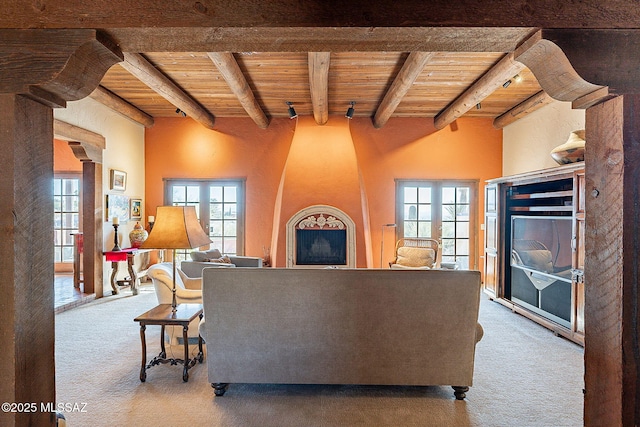 carpeted living room with plenty of natural light, beam ceiling, and wooden ceiling