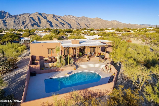 view of swimming pool with a mountain view and a patio