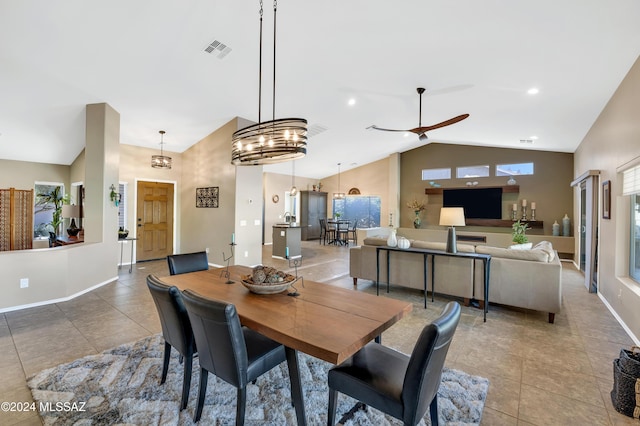 tiled dining room with ceiling fan and high vaulted ceiling