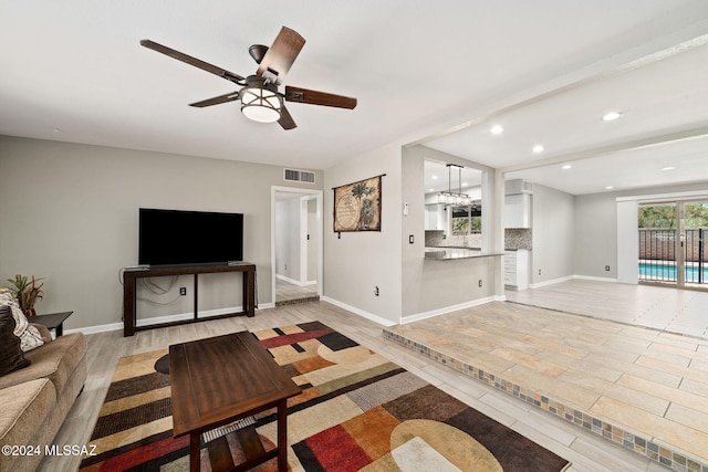 living room featuring ceiling fan and beam ceiling