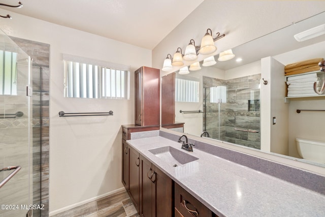 bathroom featuring vanity, hardwood / wood-style flooring, toilet, and an enclosed shower