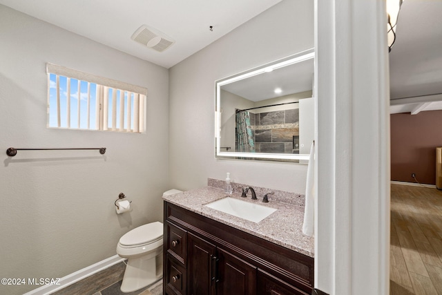 bathroom with walk in shower, vanity, and toilet