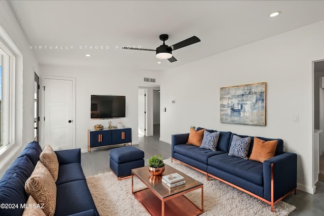 living room with ceiling fan and concrete floors