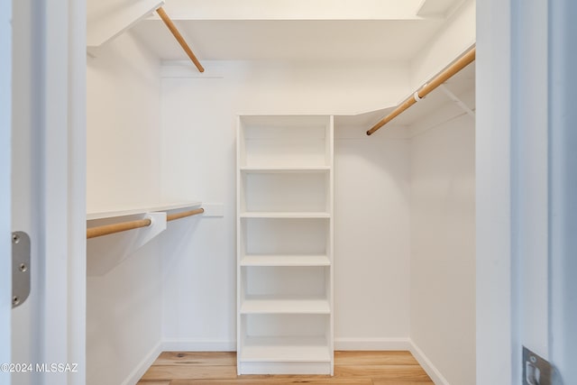 walk in closet with hardwood / wood-style flooring