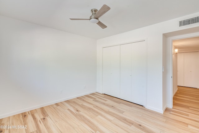 unfurnished bedroom with light hardwood / wood-style flooring, ceiling fan, and a closet