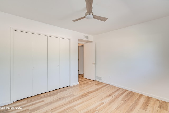 unfurnished bedroom with a closet, light wood-type flooring, and ceiling fan