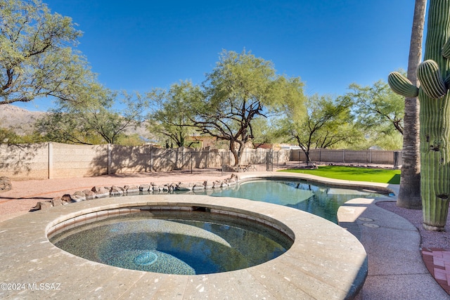 view of swimming pool with an in ground hot tub