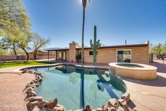 view of swimming pool featuring an in ground hot tub