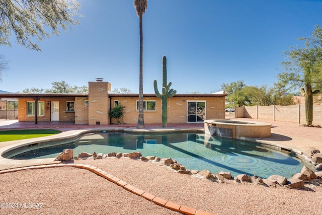 view of swimming pool featuring a patio area and an in ground hot tub