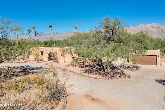 pueblo-style home featuring a mountain view and a garage