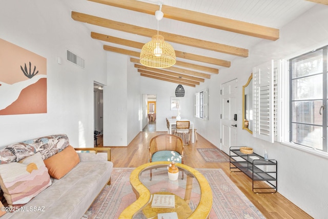 living area with vaulted ceiling with beams, light wood-style flooring, and visible vents