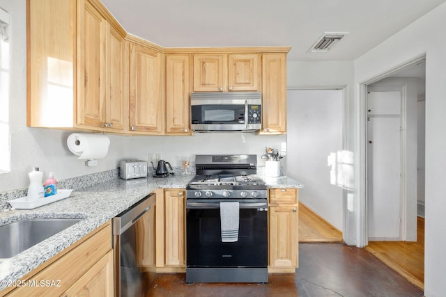 kitchen with visible vents, light brown cabinetry, light stone counters, concrete floors, and appliances with stainless steel finishes