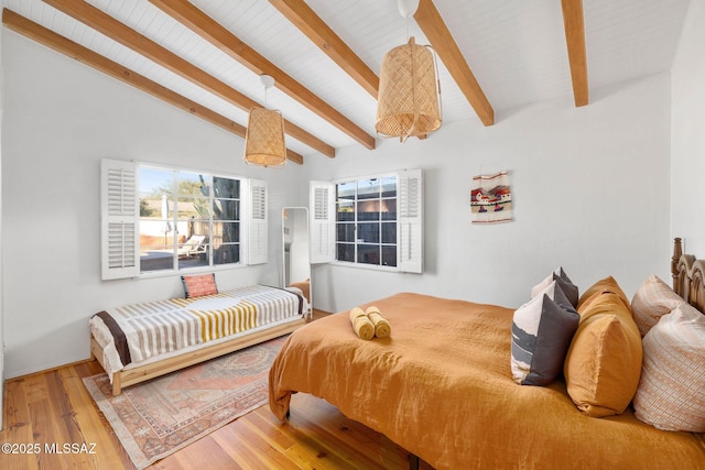 bedroom featuring vaulted ceiling with beams and wood finished floors