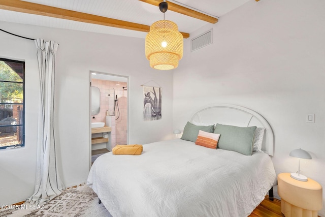 bedroom featuring beam ceiling, visible vents, light wood finished floors, and ensuite bathroom