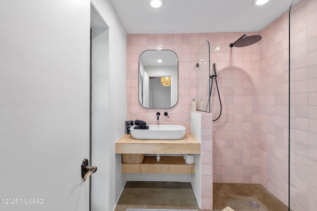 full bath featuring tasteful backsplash, walk in shower, recessed lighting, tile walls, and a sink