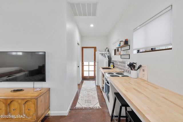 kitchen featuring white electric stove, visible vents, decorative backsplash, wood counters, and a sink