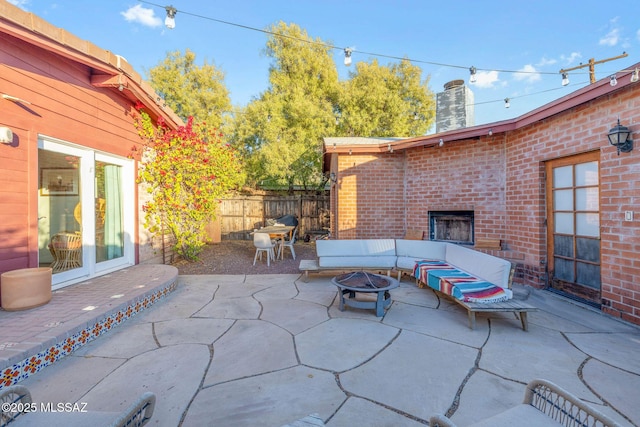 view of patio / terrace with an outdoor brick fireplace and fence